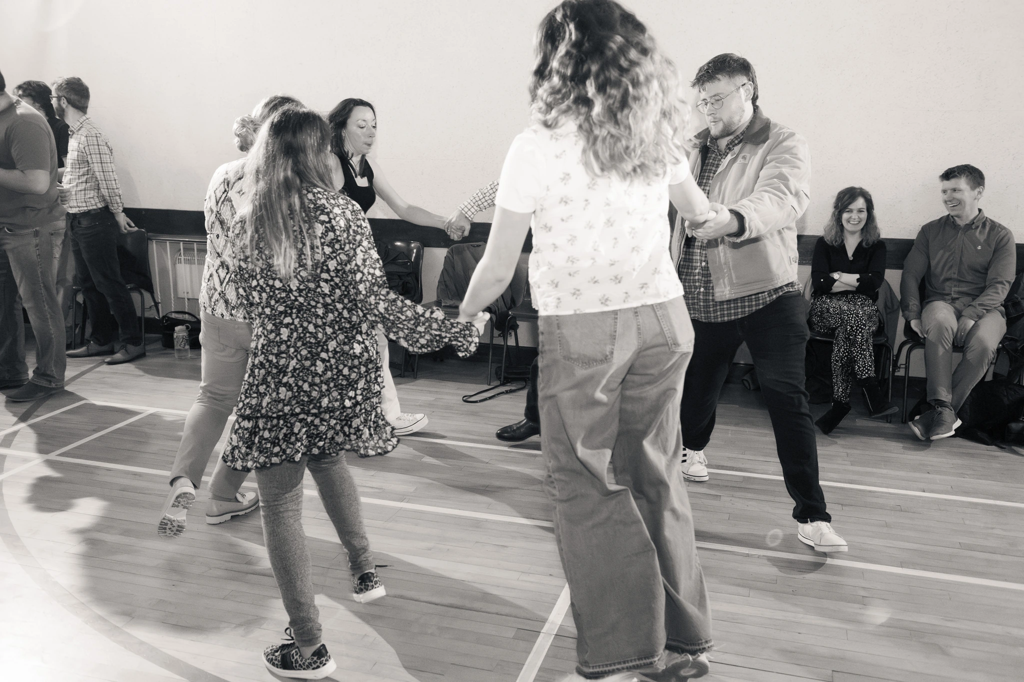 black and white photograph of a group of people dancing in a dance floor