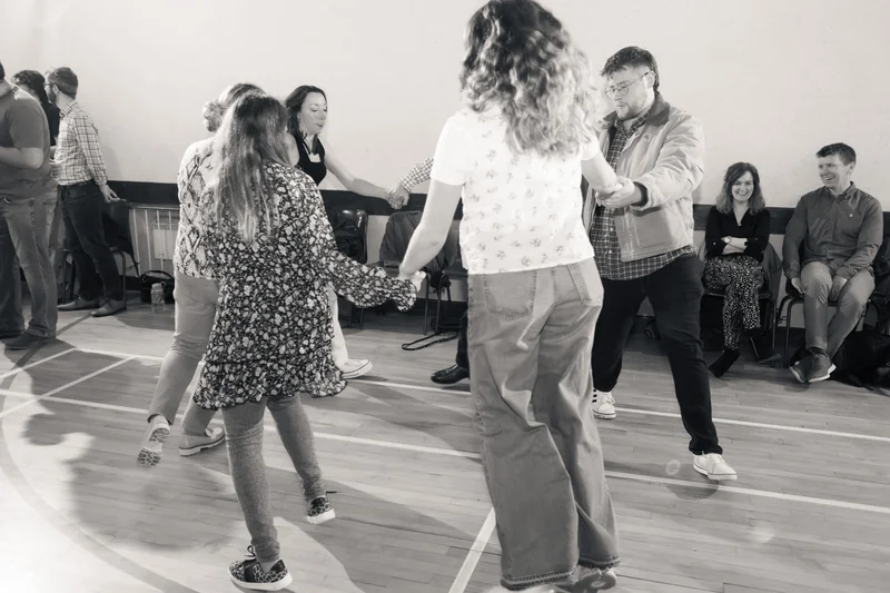black and white photograph of a group of people dancing in a dance floor