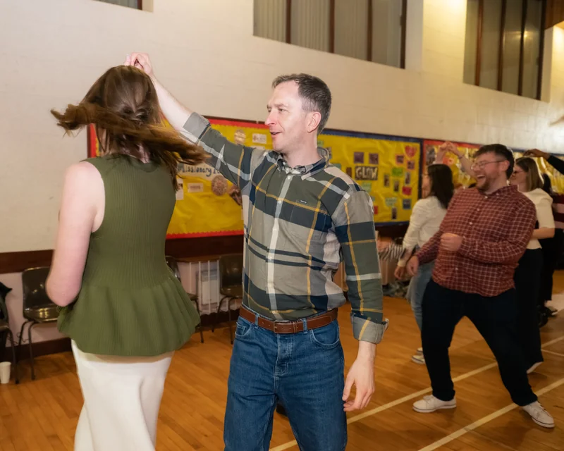 a man is dancing with a woman in a gymnasium