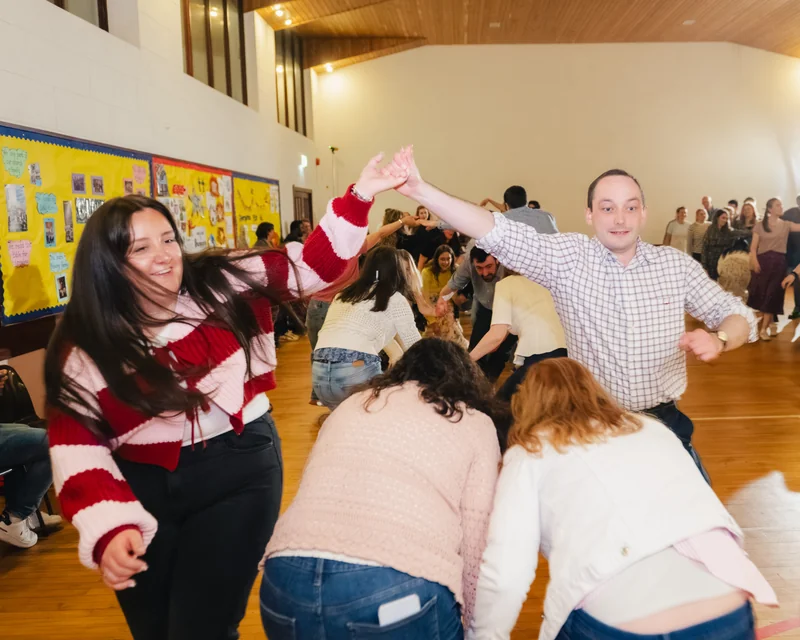 a group of people dancing on a dance floor in a gymnasium