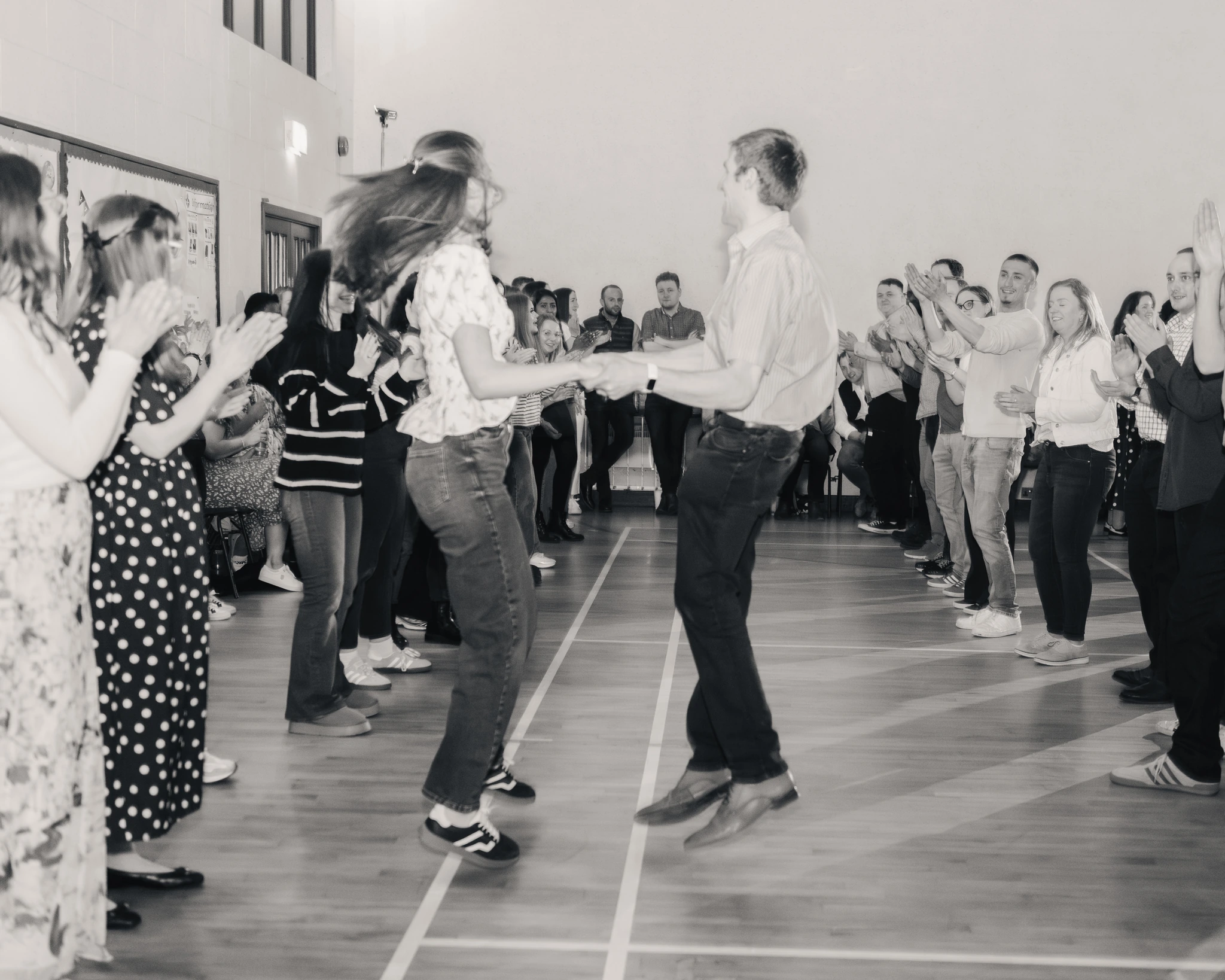 black and white photograph of a crowd of people dancing in a gymnasium
