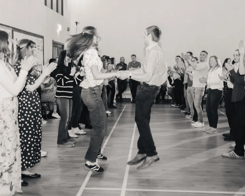 black and white photograph of a crowd of people dancing in a gymnasium