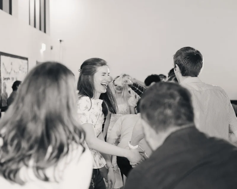 black and white photograph of a group of people laughing in a room