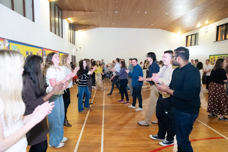 a group of people clapping in a gymnasium