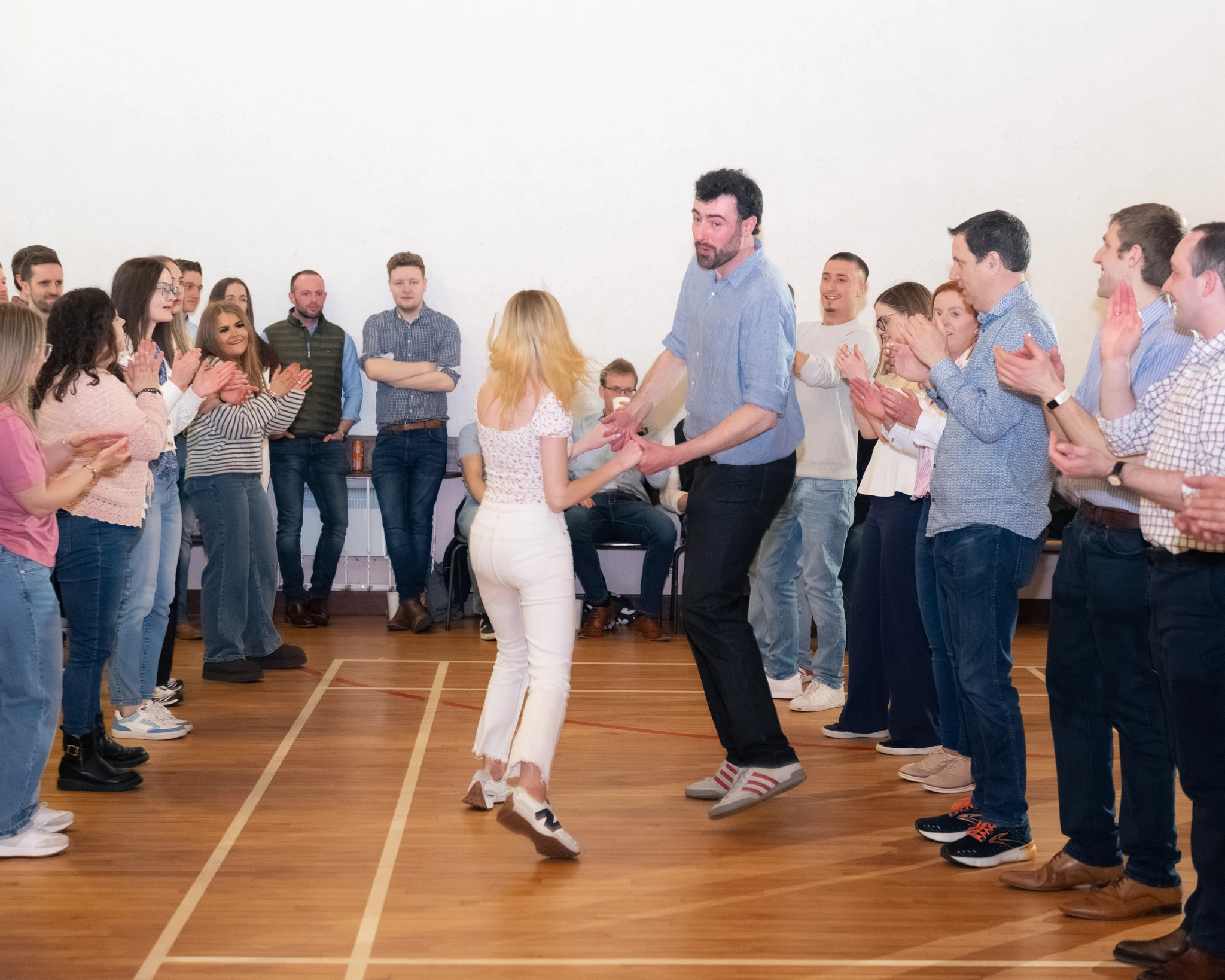 a man and woman dancing in front of a crowd of people