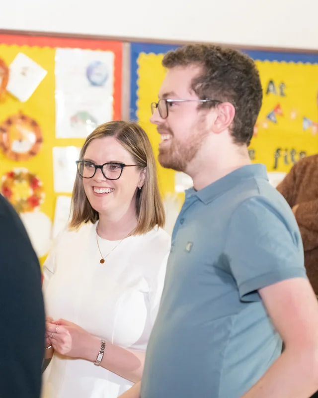 a group of people standing around a table in a classroom