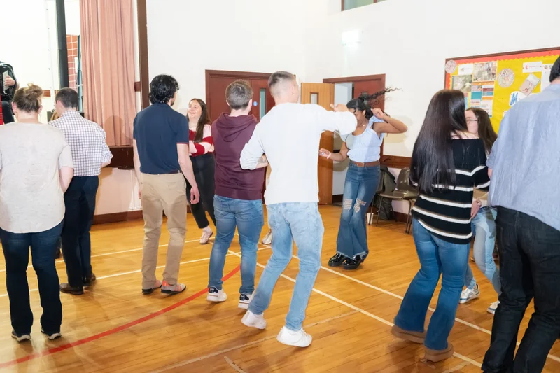 a group of people dancing in a gymnasium