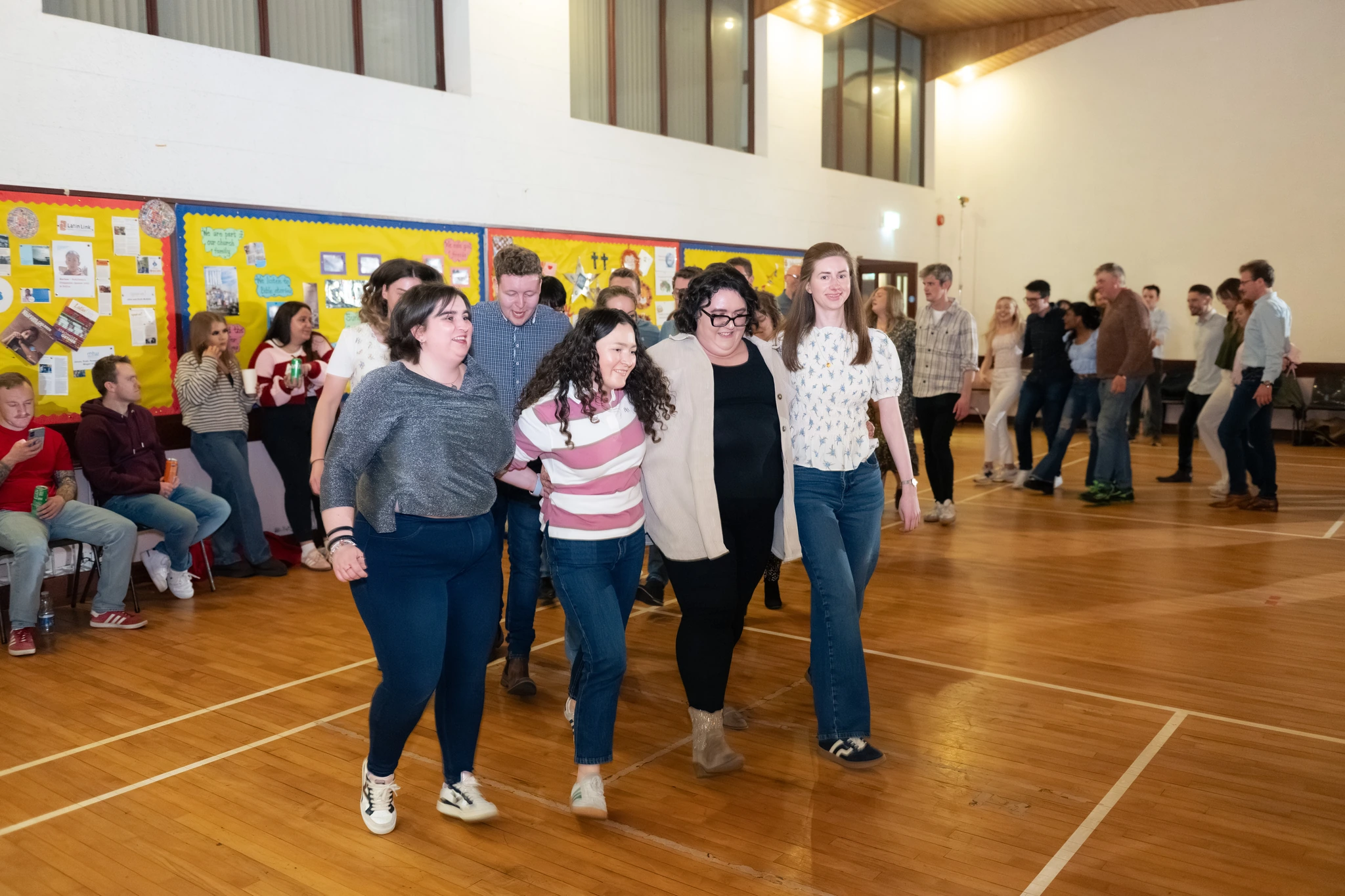 a group of people walking down a hallway in a school hall