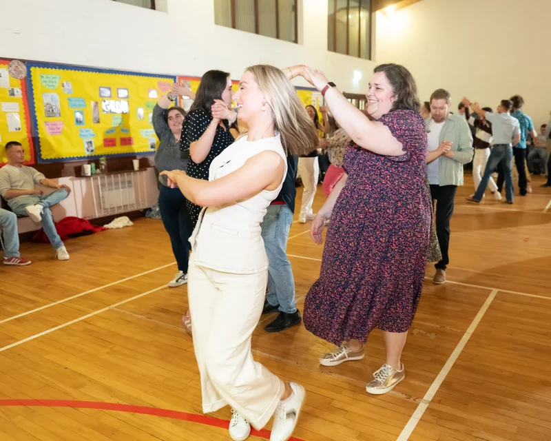 a group of people dancing in a gymnasium