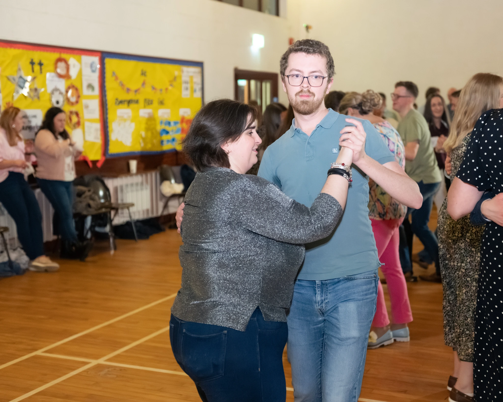 a man and a woman dancing in a room full of people