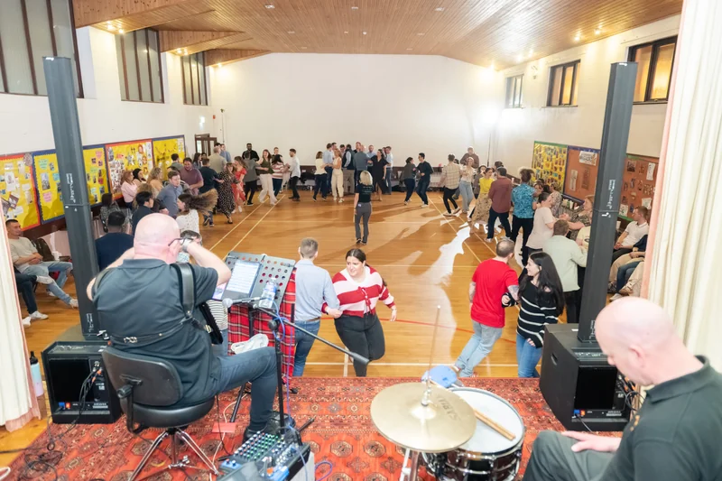a group of people watching a band perform in a large room