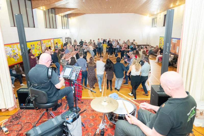 a group of people playing drums in a large room