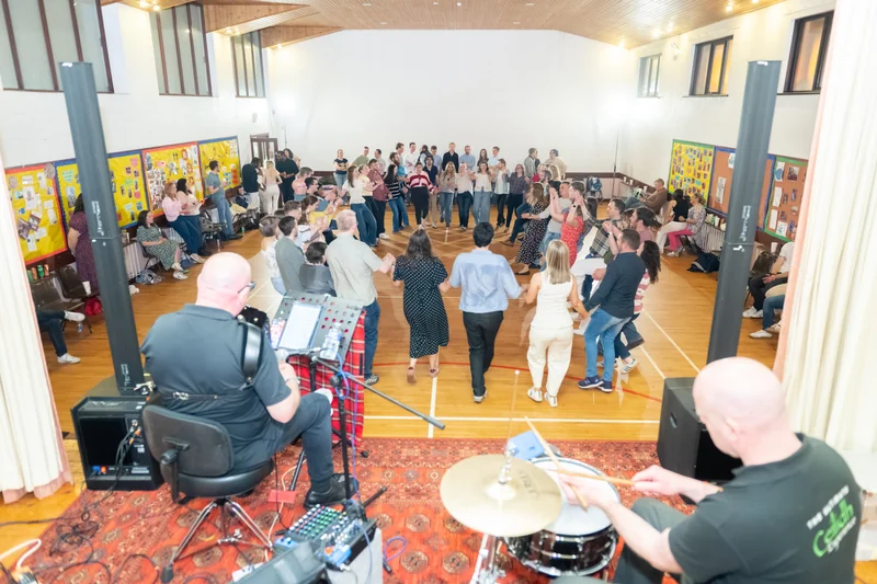 a group of people watching a band play in a large room