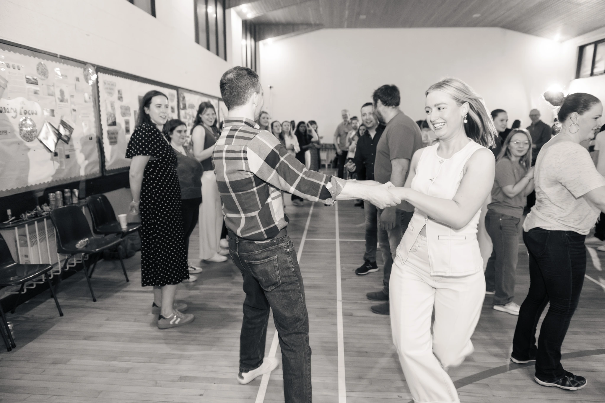 a man and woman dancing in a room full of people