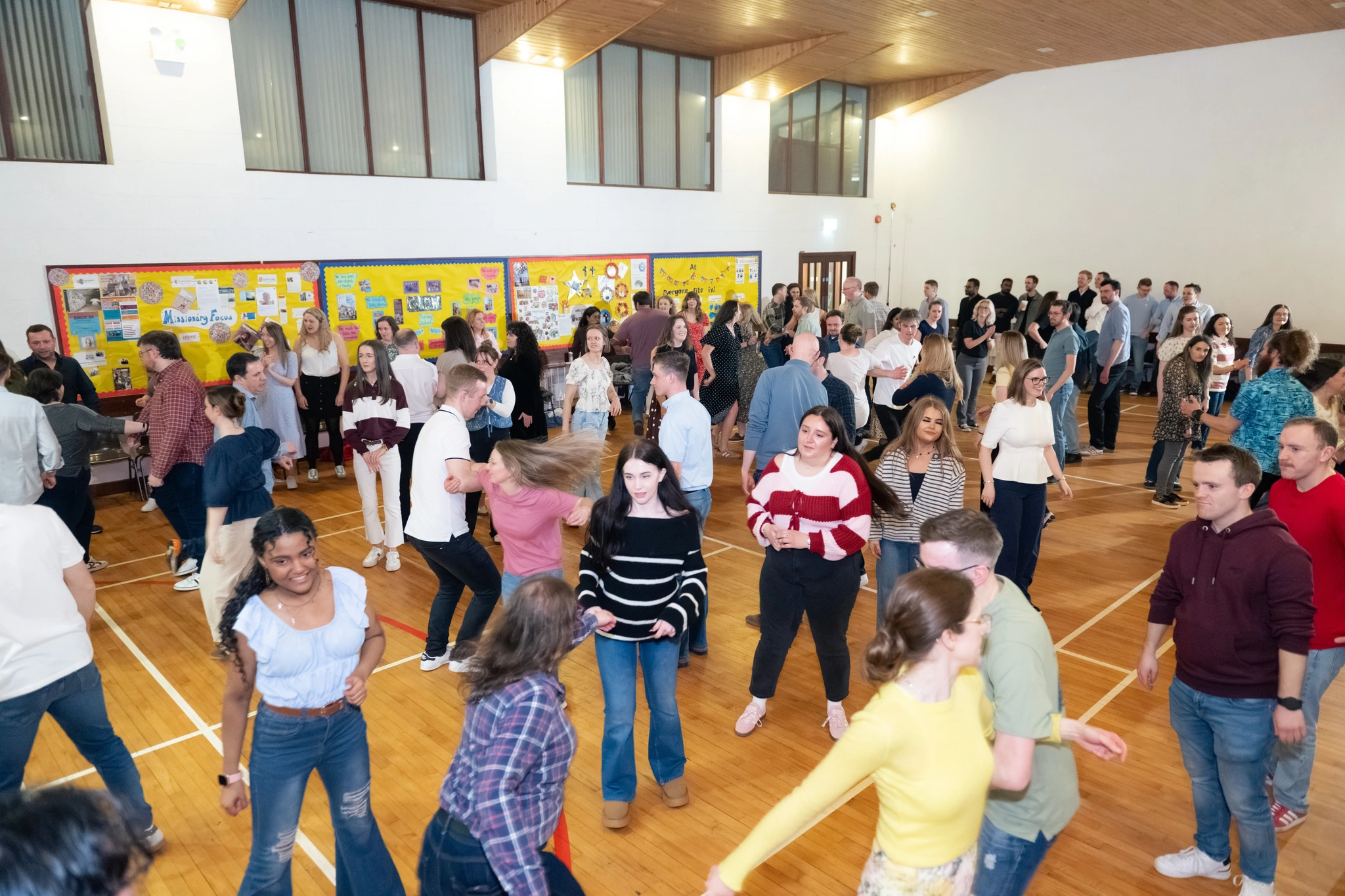 a large group of people dancing in a room