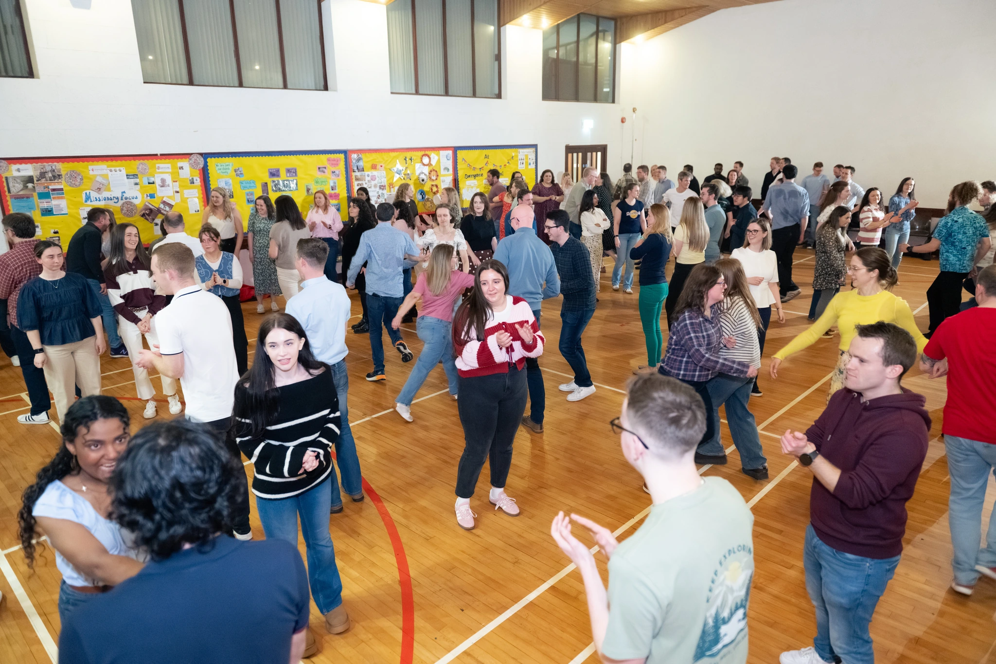 a large group of people dancing in a gymnasium
