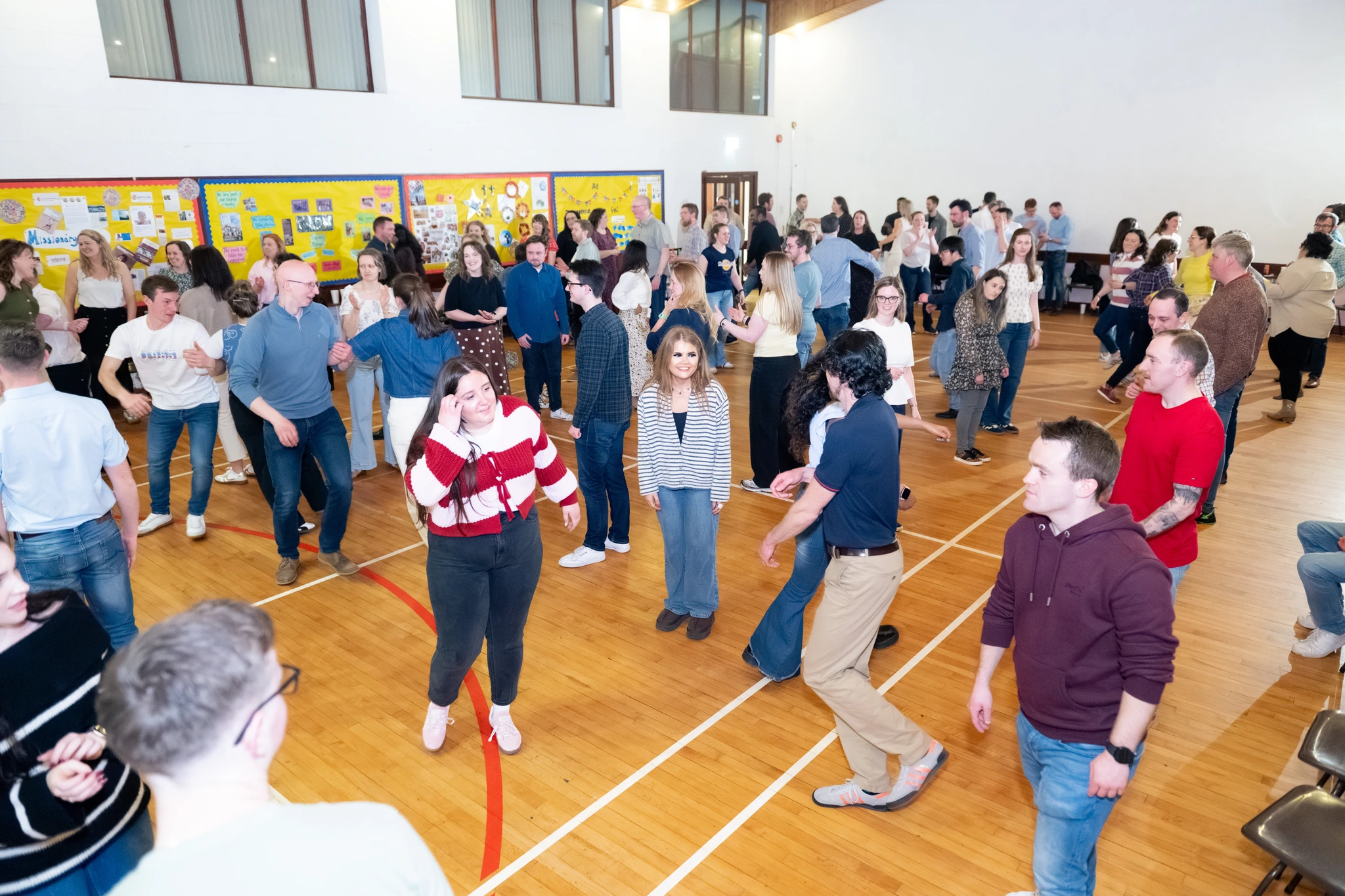 a large group of people dancing in a gymnasium