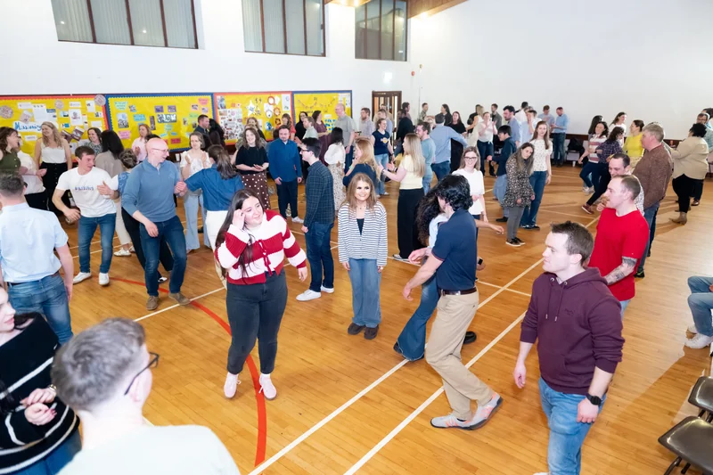 a large group of people dancing in a gymnasium