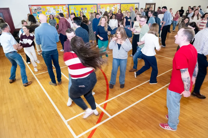 a group of people dancing in a gymnasium