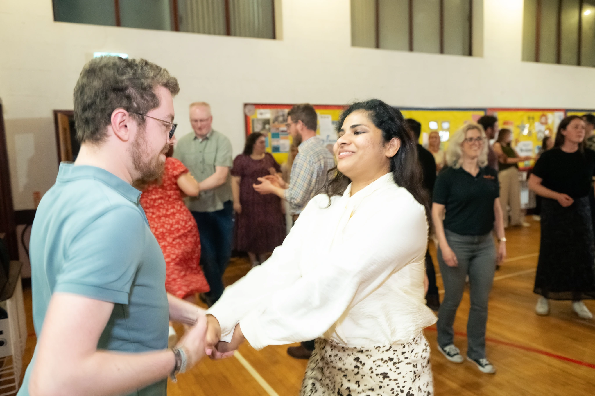 a man and woman dancing in a school hall