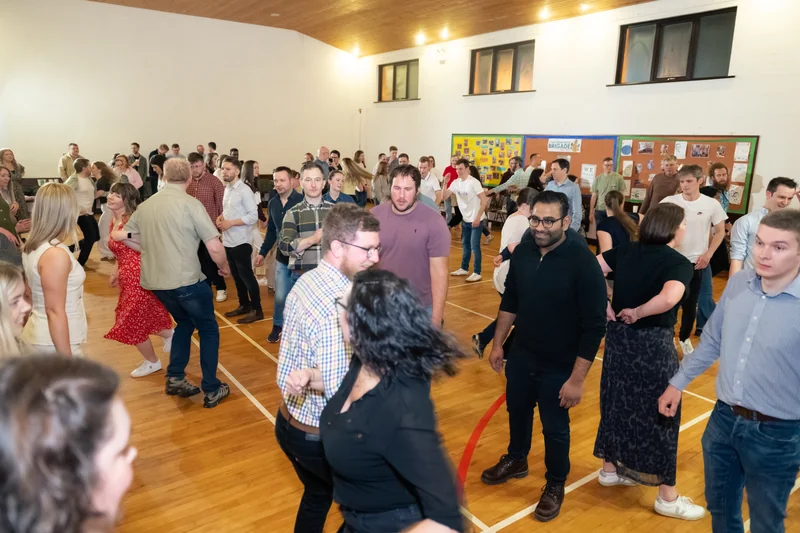 a crowd of people dancing in a gymnasium
