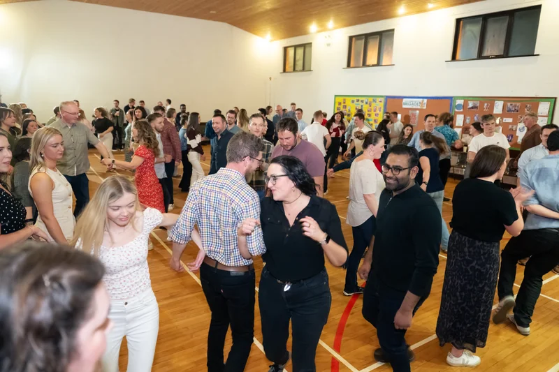 a group of people dancing in a gymnasium