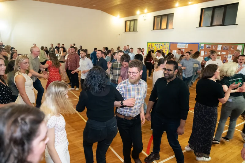a crowd of people dancing in a gymnasium