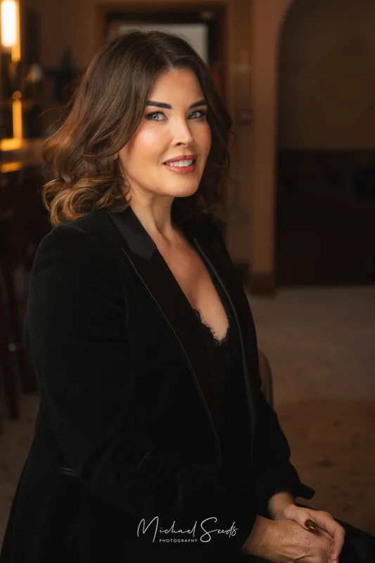 a woman in a black tuxedo posing for a photo