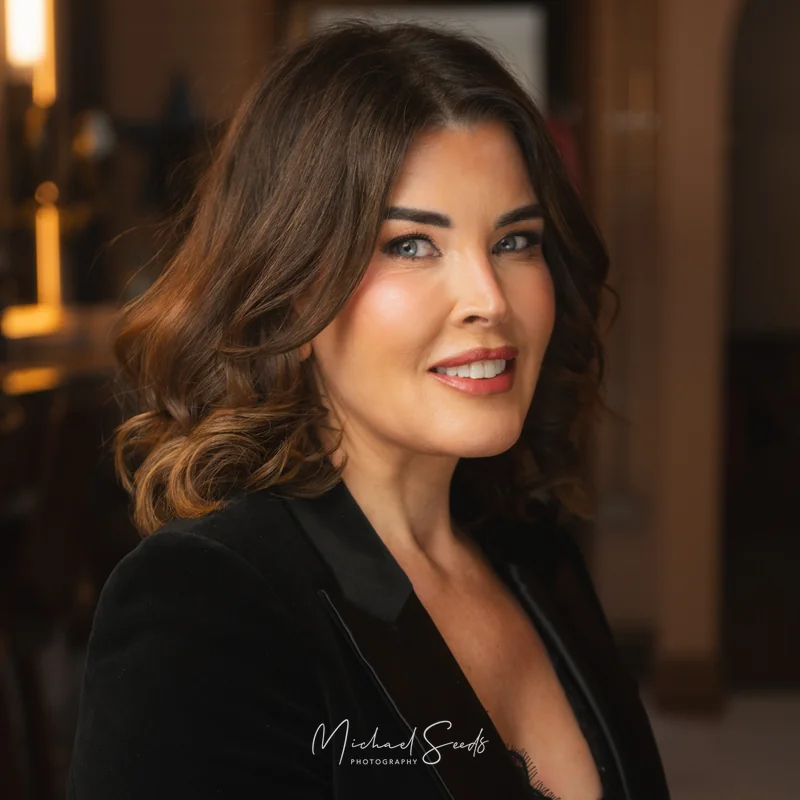 a woman in a black tuxedo posing in front of a mirror