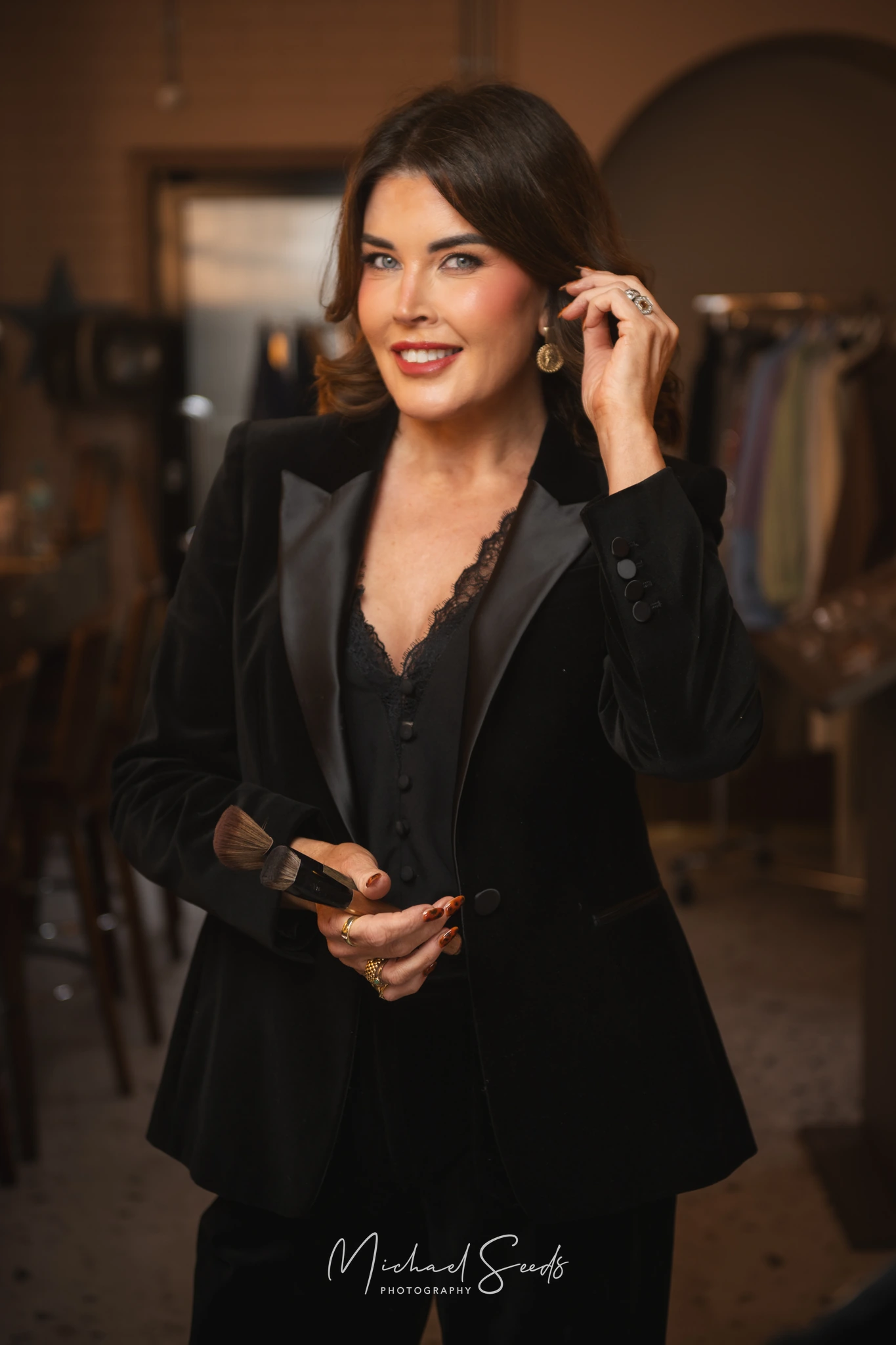 a woman wearing a black velvet suit and a pair of glasses