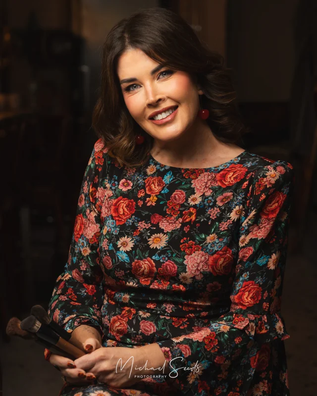 a woman in a floral dress with a brush in her hand