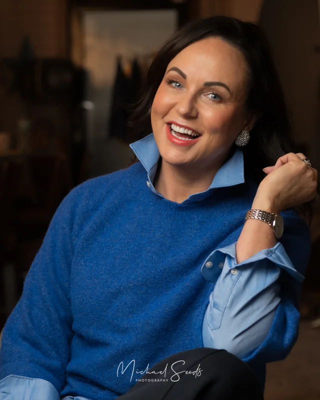 a woman wearing a blue sweater and a pair of jeans