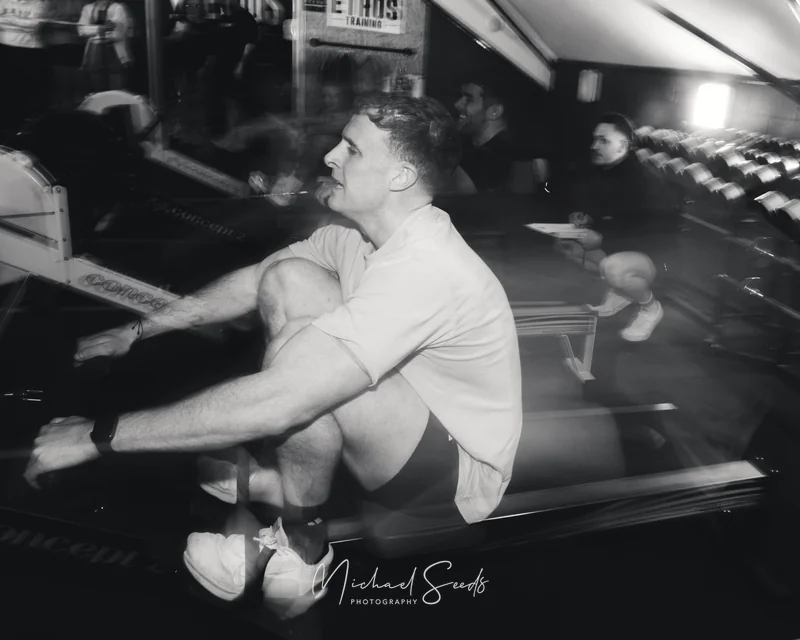 a man sitting on a rowing machine in a gym