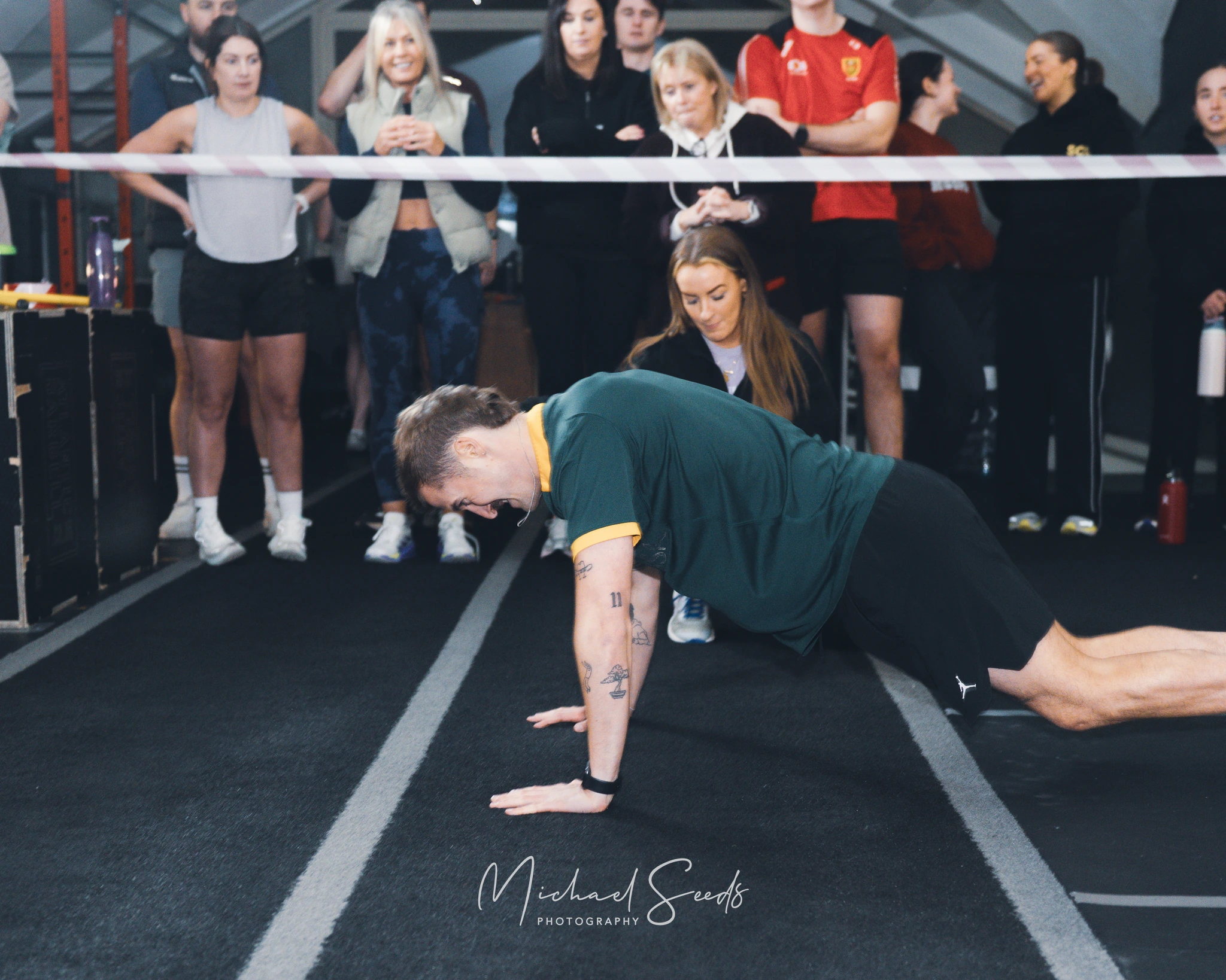 a man doing push ups in front of a crowd of spectators