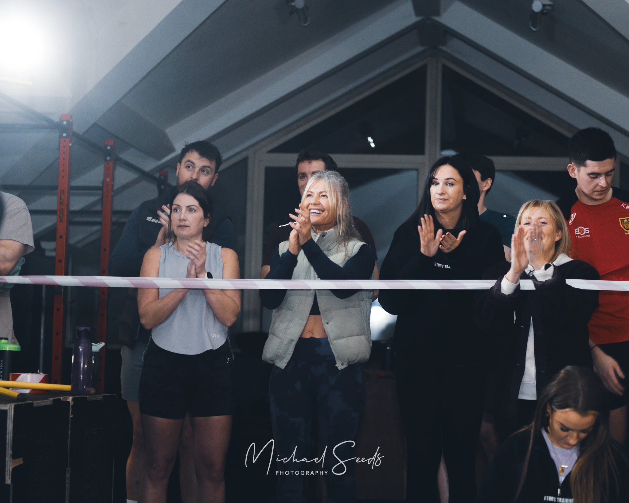 a group of people clapping in front of a boxing ring