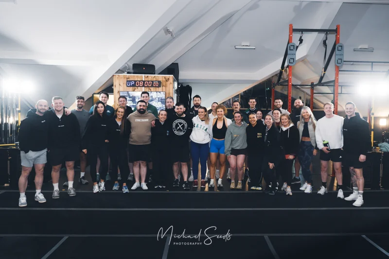 a group of people posing in front of a rowing machine