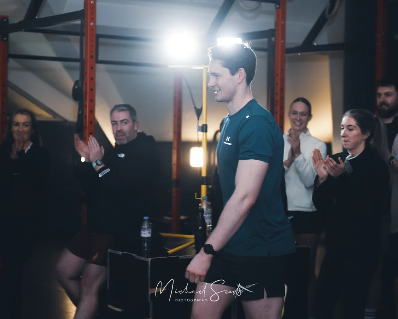 a man is standing in front of a crowd of spectators in a gym