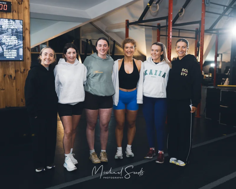 a group of women standing next to each other in a gym