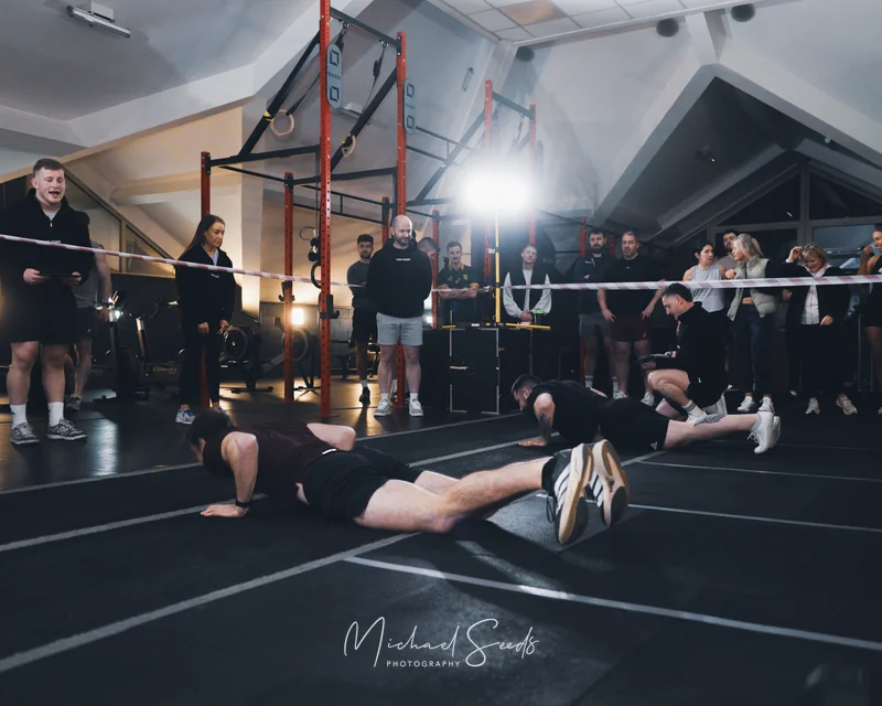 a man doing a push up in front of a group of people