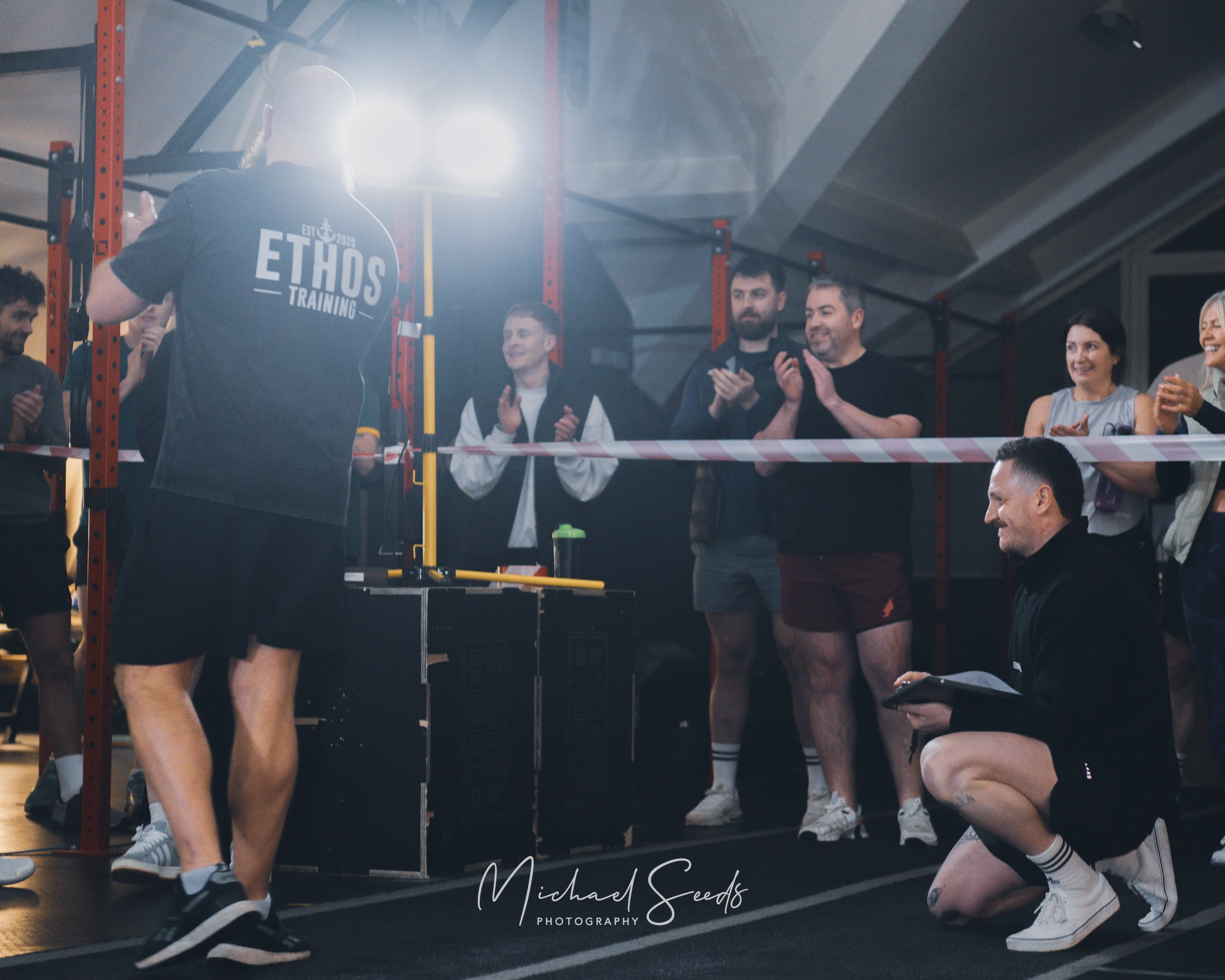 a group of people standing in front of a boxing ring in a gym