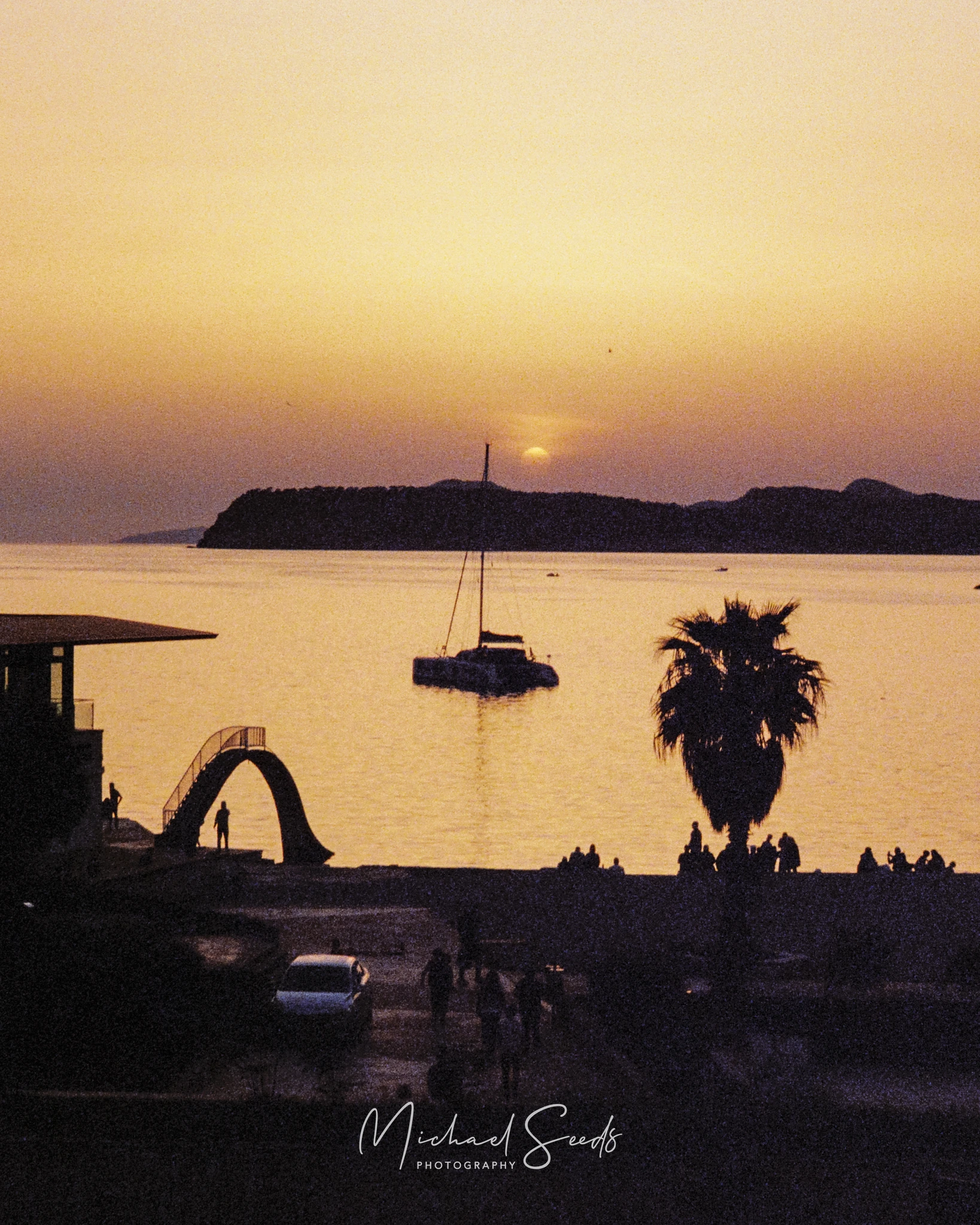 a sunset over a bay with a boat in the distance