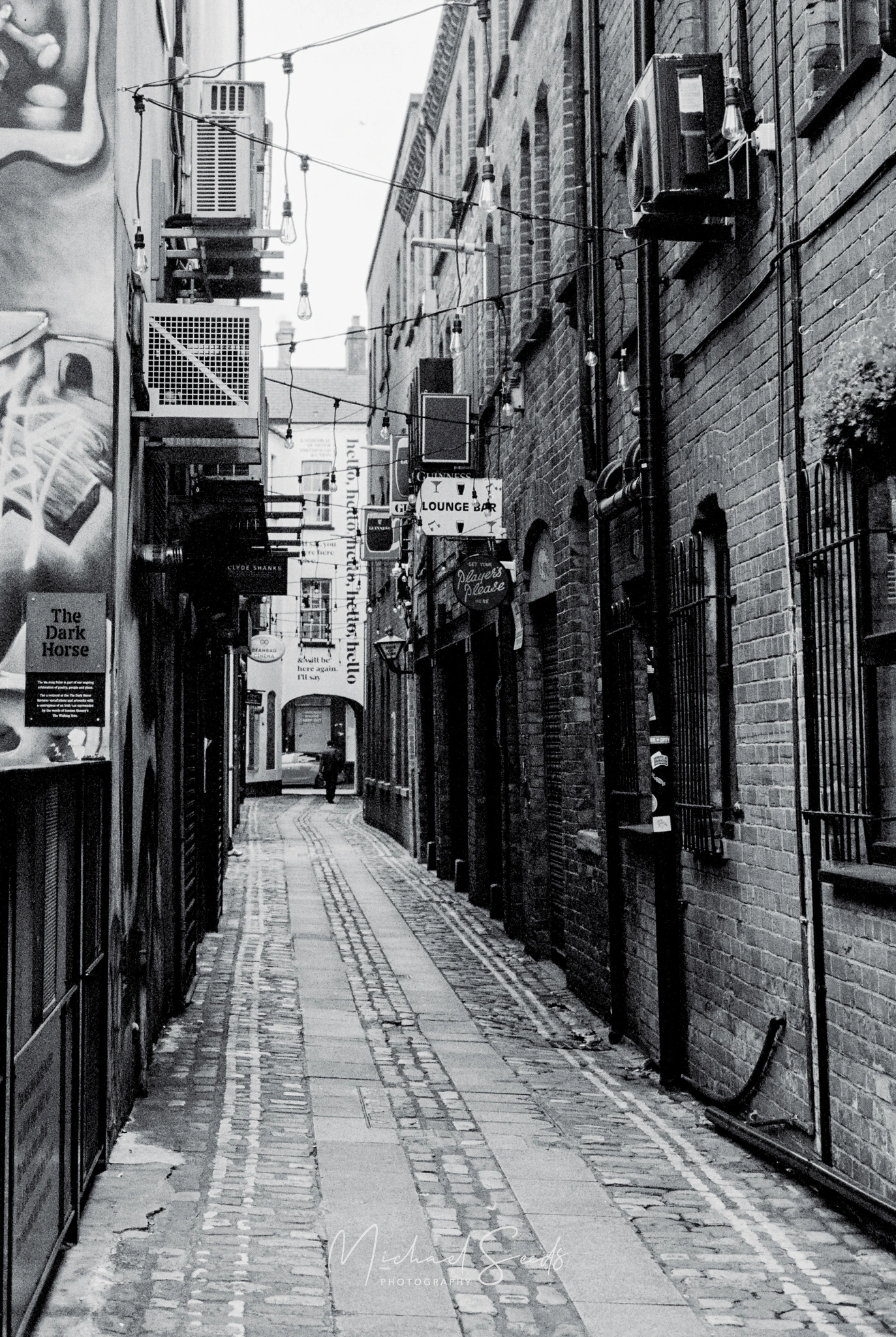 black and white image of a narrow alleyway in london