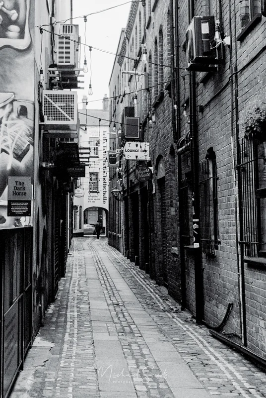 black and white image of a narrow alleyway in london
