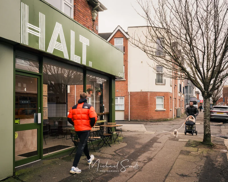 a woman walks down a street with a baby stroller in front of a restaurant