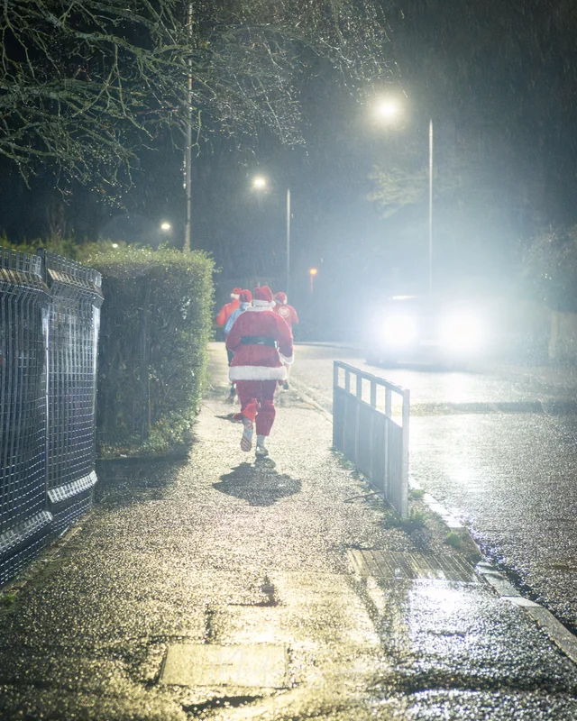 santa running down the street at night