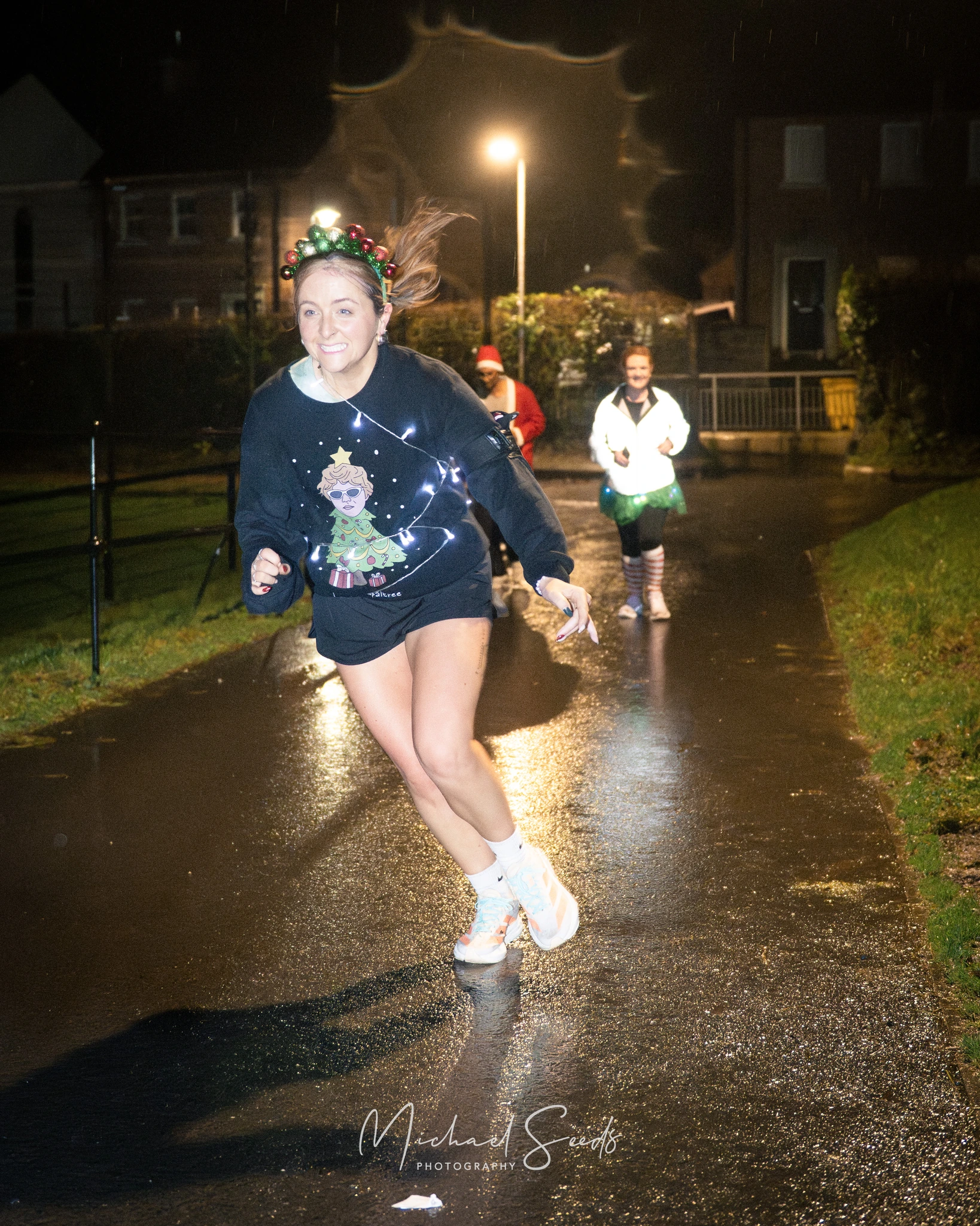 a young girl runs down a street in a rainy night
