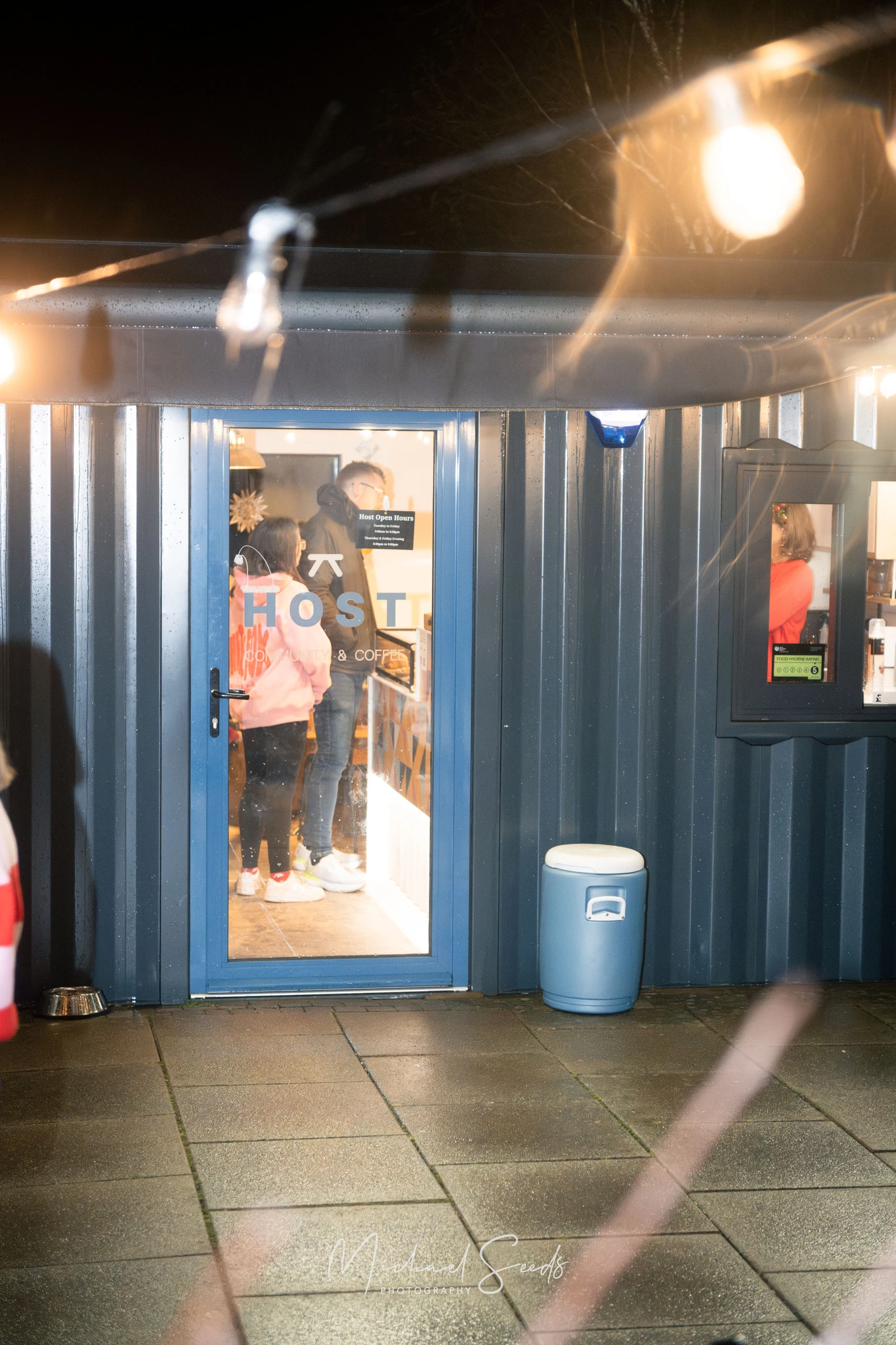 a group of people standing in front of a blue container