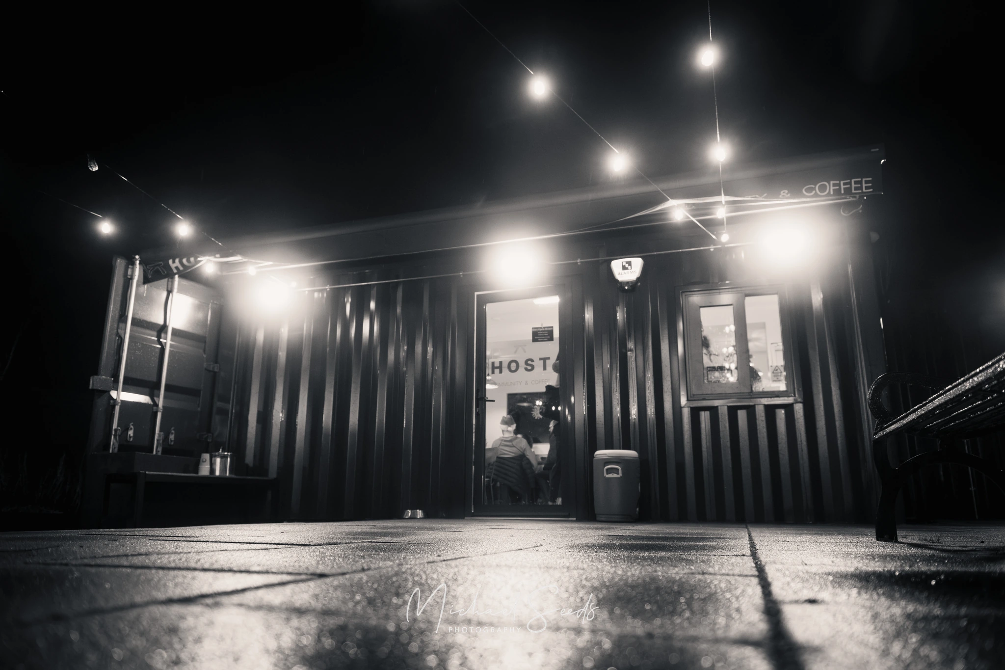 a black and white image of a coffee shop at night