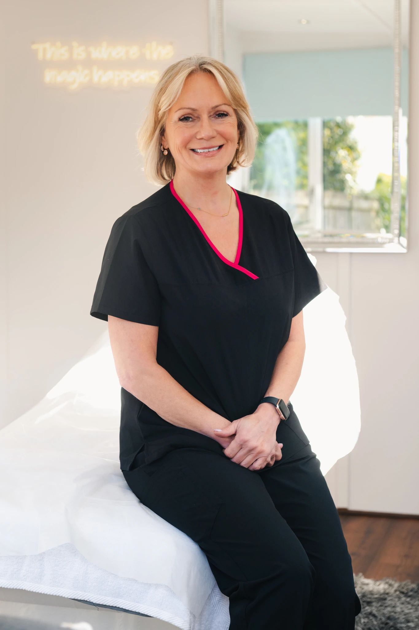 a woman sitting on a bed in a treatment room