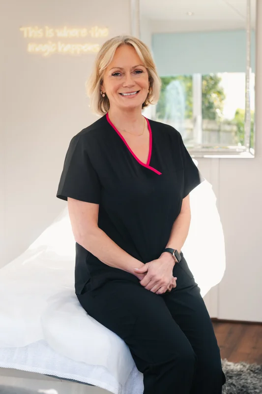 a woman sitting on a bed in a treatment room